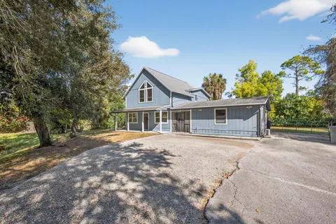 a front view of a house with a yard and trees