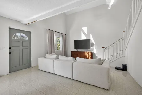 a living room with furniture and kitchen view