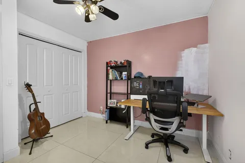 a view of a house with a yard and a large tree