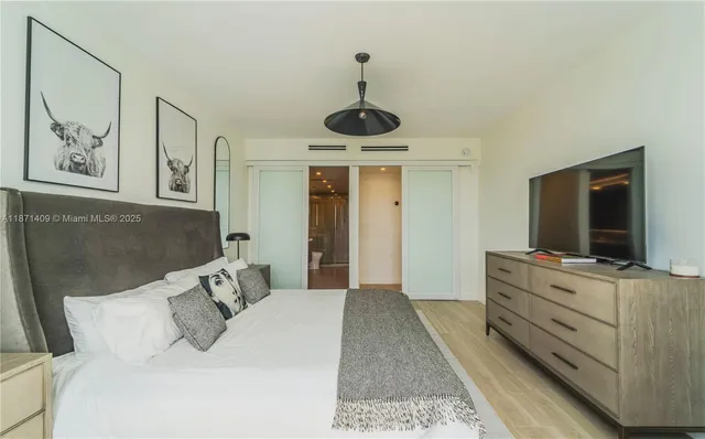 a bedroom with a bed and a flat screen tv