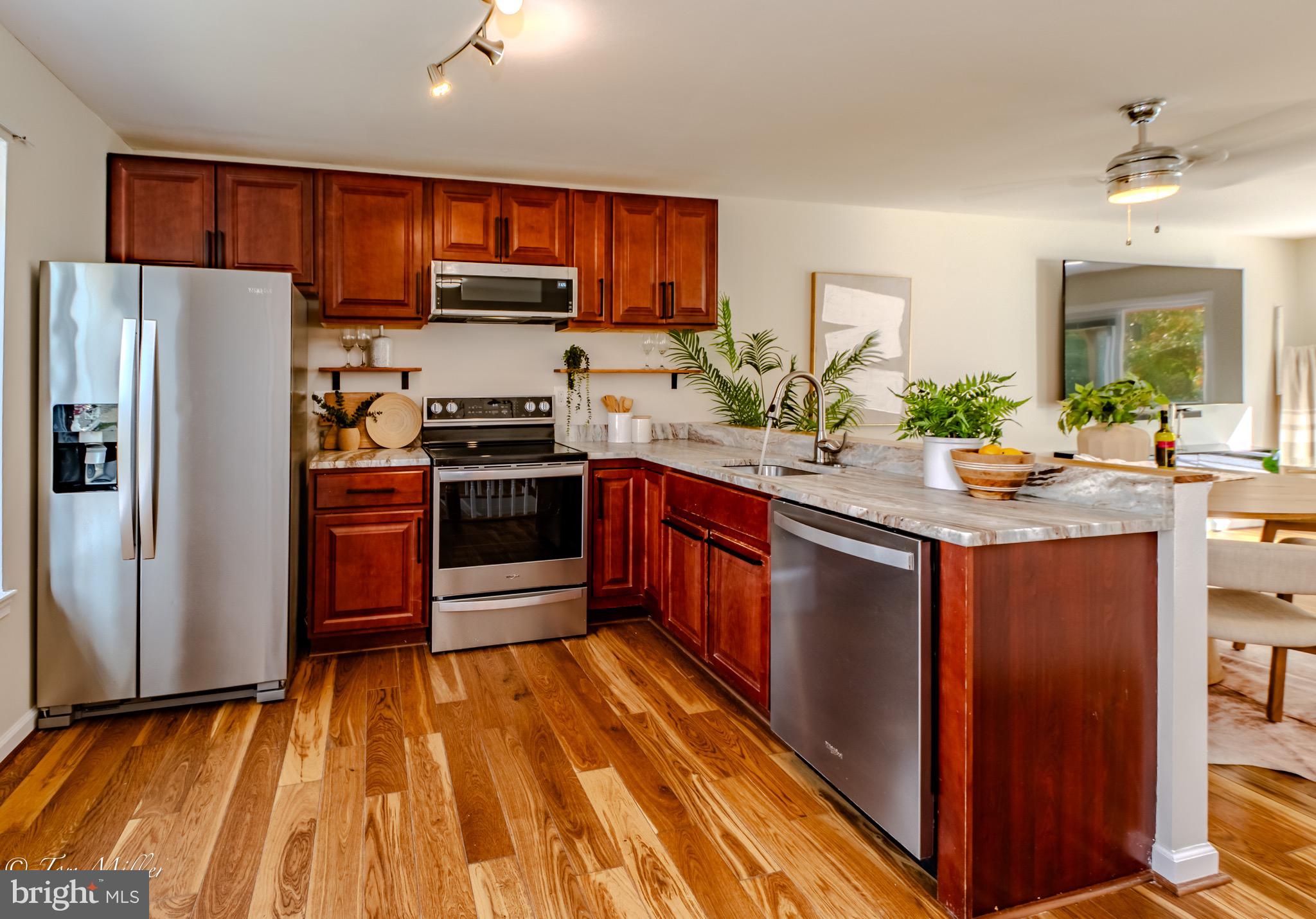 9544 Gunhill Circle Nottingham, MD 21236 - Photo 6 of 56 a kitchen with stainless steel appliances granite countertop wooden cabinets a stove a sink and a refrigerator