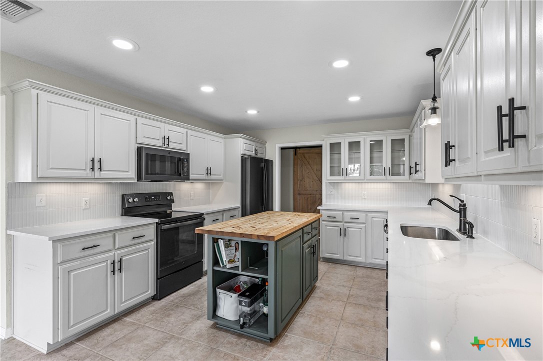 3000 West Amity Road Belton, TX 76513 - Photo 13 of 45 a kitchen with a stove sink and cabinets