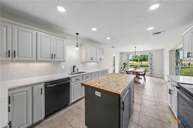 a view of a dining room and a kitchen with a table chairs
