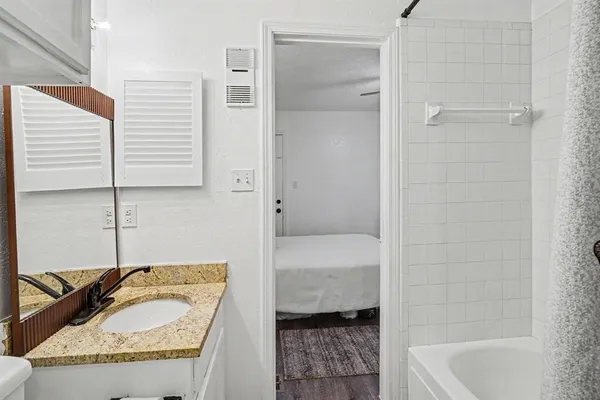 a bedroom with a bed dresser and wooden floor