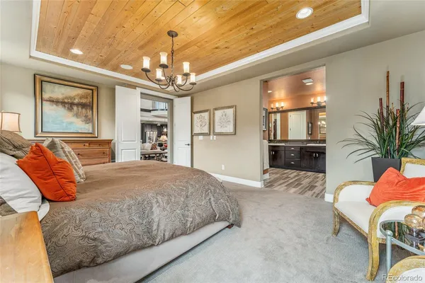 a bedroom with a large bed and a chandelier