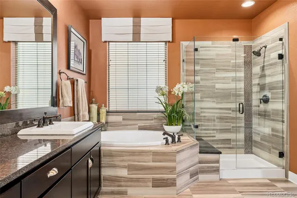 a bathroom with a granite countertop sink and a bathtub