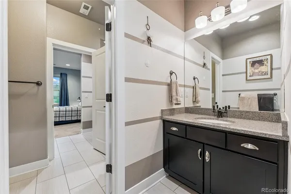 a en suite bathroom with a granite countertop sink a mirror and a