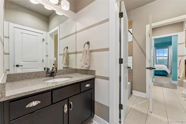 a bathroom with a granite countertop sink a mirror and a vanity