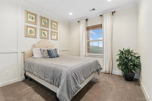 a bedroom with a bed and a potted plant