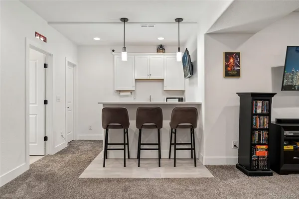 a kitchen with stainless steel appliances granite countertop a table chairs and a refrigerator