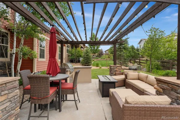 a view of a patio with couches table and chairs and potted plants