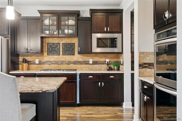 a kitchen with stainless steel appliances granite countertop a sink and a stove top oven
