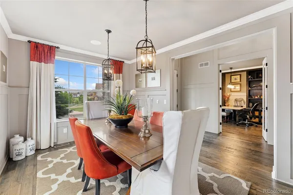 a dining room with furniture a chandelier and wooden floor