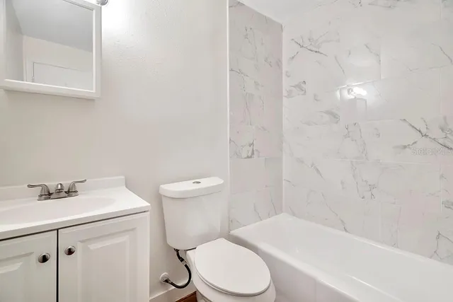 a white toilet sitting next to a bathroom sink