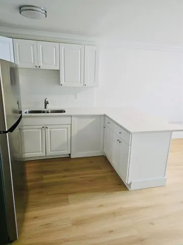 a view of a kitchen with sink and cabinets