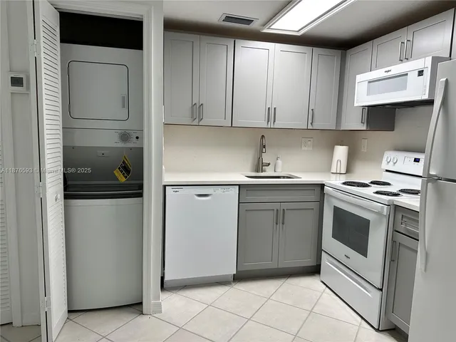 a kitchen with white cabinets and appliances