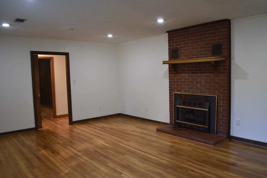 959 Pleasant Valley Road Murphy, NC 28906 - Photo 5 of 18 a view of an empty room with wooden floor and a fireplace
