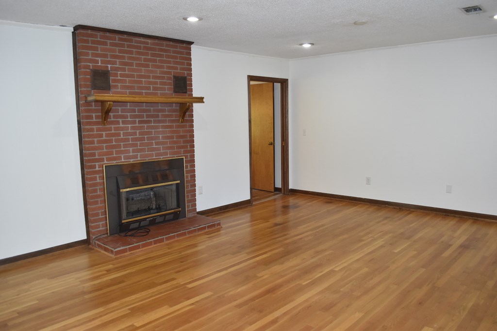 959 Pleasant Valley Road Murphy, NC 28906 - Photo 6 of 18 a view of empty room with wooden floor and fireplace