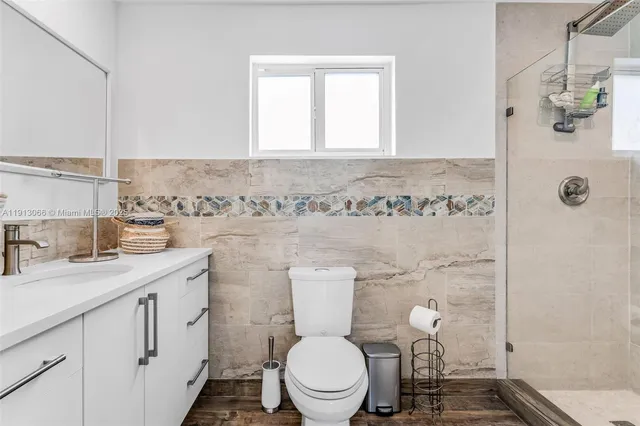 a bathroom with a granite countertop toilet sink and mirror