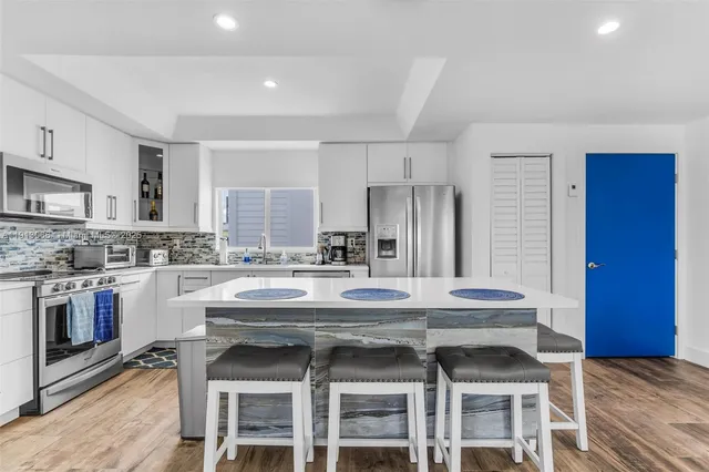 a kitchen with a stove a sink and chairs