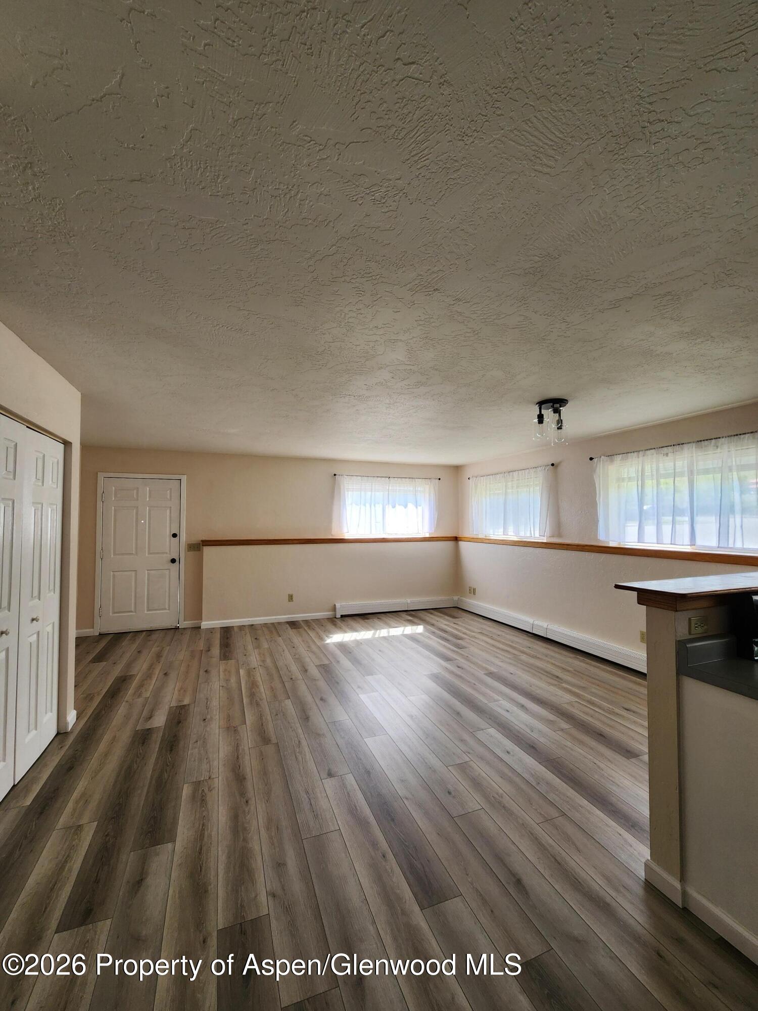 883 Taugenbaugh Boulevard Rifle, CO 81650 - Photo 6 of 18 an empty room with wooden floor closet and windows