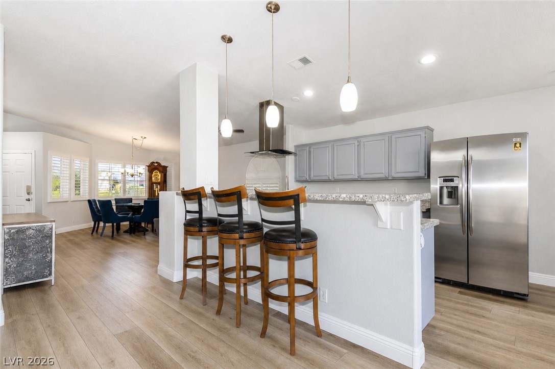 2278 Ramsgate Drive Henderson, NV 89074 - Photo 7 of 34 A contemporary kitchen features a breakfast bar with pendant lighting, perfect for casual dining and entertaining.