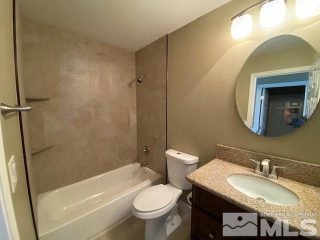 18020 Hazelnut Drive Reno, NV 89508 - Photo 14 of 19 a bathroom with a granite countertop toilet a sink and a mirror