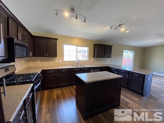 18020 Hazelnut Drive Reno, NV 89508 - Photo 4 of 19 a kitchen with granite countertop a stove top oven a sink dishwasher and wooden cabinets with wooden floor