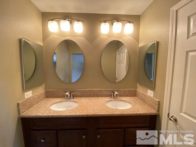 18020 Hazelnut Drive Reno, NV 89508 - Photo 8 of 19 a bathroom with a granite countertop double vanity sinks and a mirror