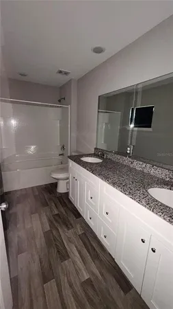 a spacious bathroom with a granite countertop sink and a mirror