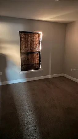 a view of a room has an empty space and a window