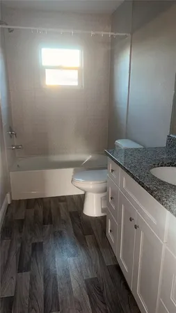 a en suite bathroom with a granite countertop sink and a mirror