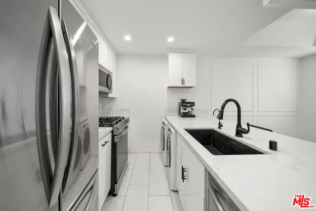 a kitchen with stainless steel appliances a sink a stove and a refrigerator