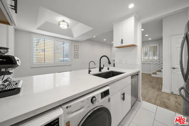 a view of a sink a washer and dryer