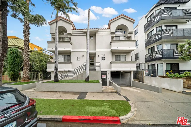 a view of a white building with a swimming pool