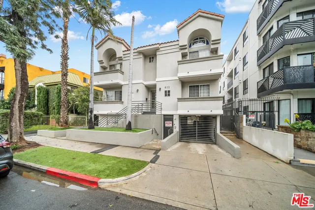 a front view of a house with a garden and plants