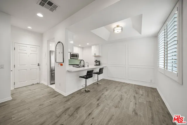a view of a kitchen and dining room with wooden floor