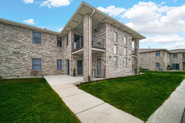 a view of a brick house with a yard