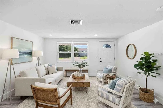 a view of a room with wooden floor and a bathroom