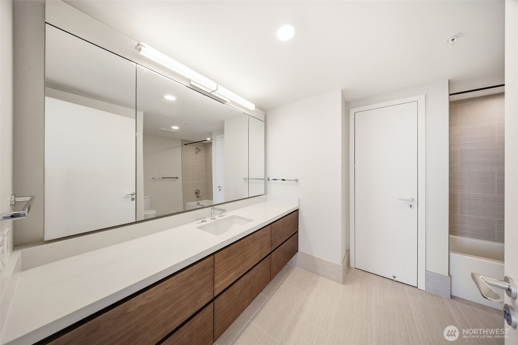 121 Stewart Street, Unit 1803 Seattle, WA 98101 - Photo 15 of 28 a bathroom with a double vanity sink and mirror