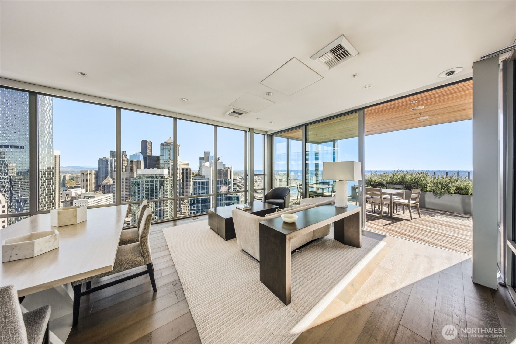 121 Stewart Street, Unit 1803 Seattle, WA 98101 - Photo 26 of 28 a living room with furniture large windows and wooden floor