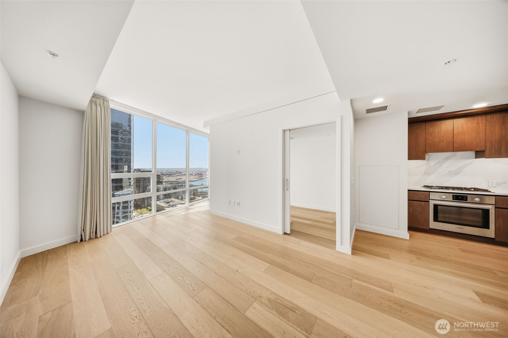 121 Stewart Street, Unit 1803 Seattle, WA 98101 - Photo 4 of 28 a view of empty room with a fireplace and cabinet