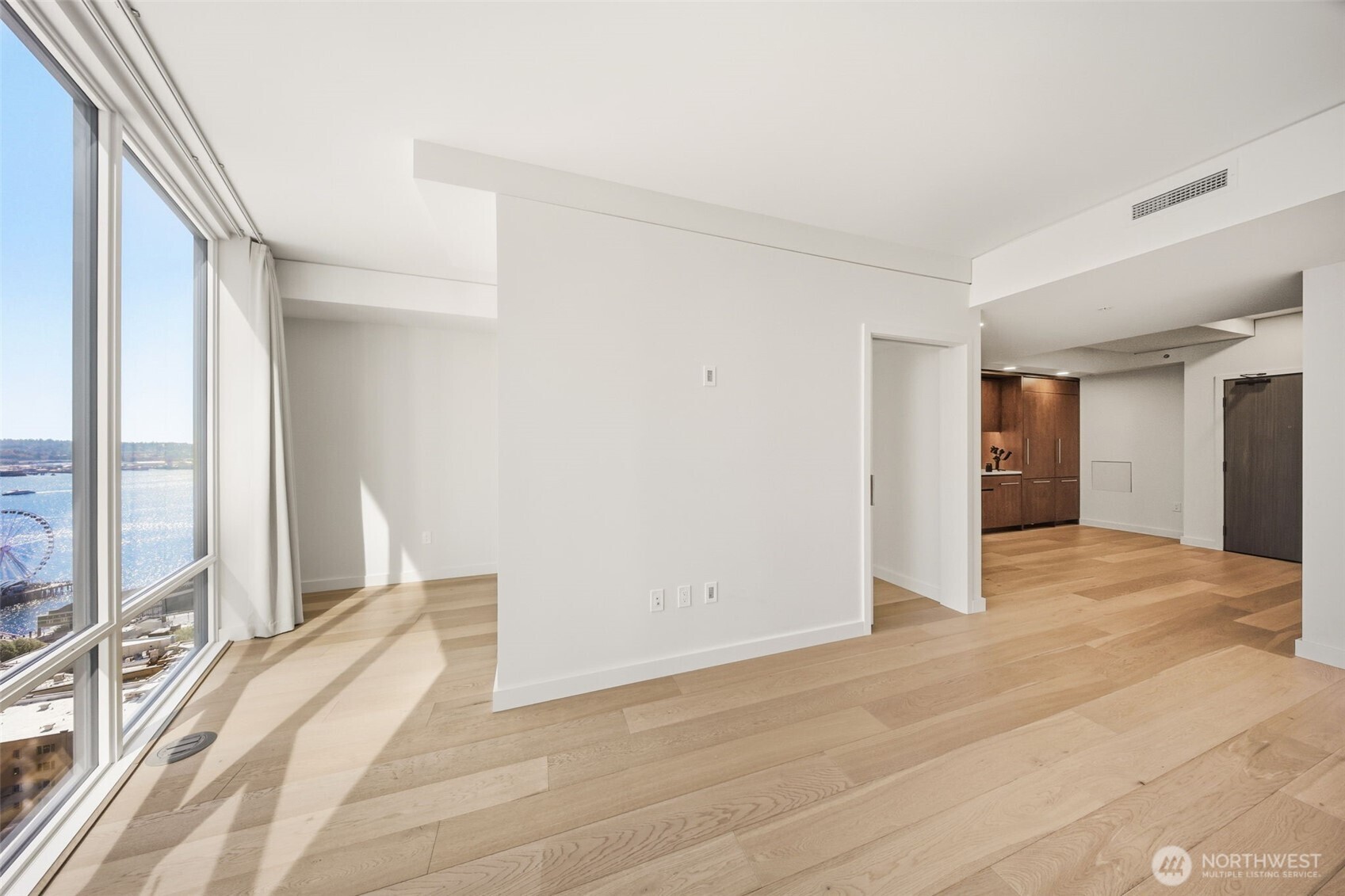 121 Stewart Street, Unit 1803 Seattle, WA 98101 - Photo 9 of 28 a view of a bedroom with a large window and wooden floor
