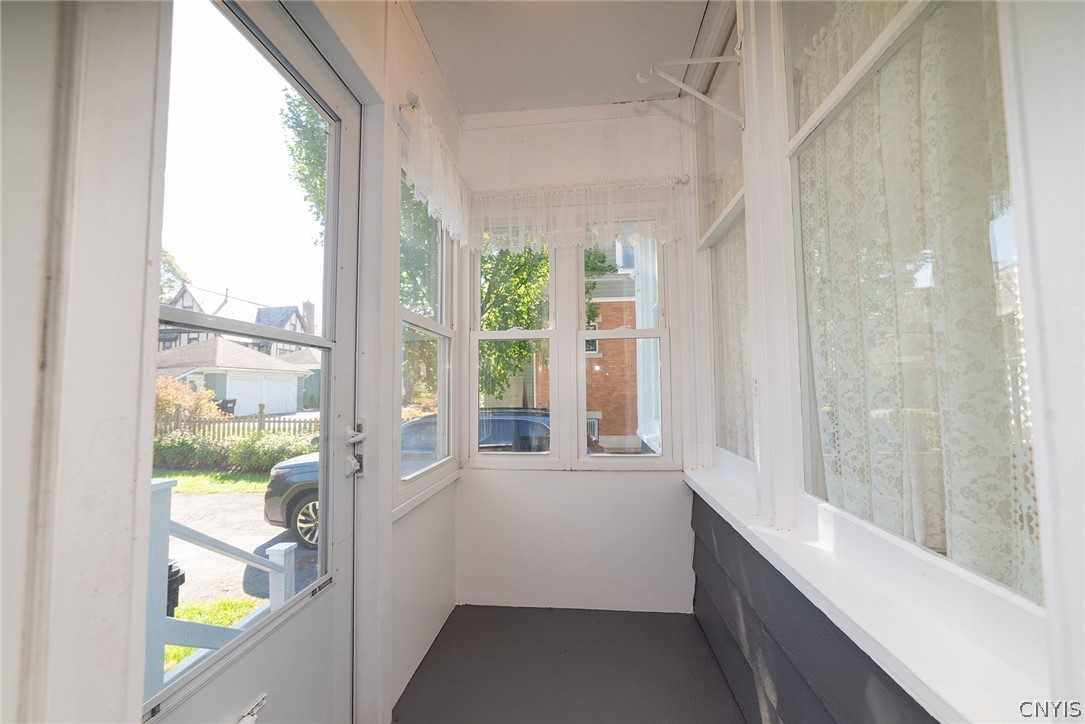 167 Beverly Road Syracuse, NY 13207 - Photo 26 of 50 An enclosed entryway porch with classic siding details and multiple windows overlooking the driveway.