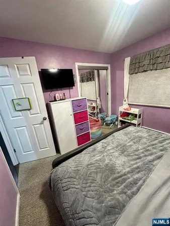 a bedroom with a bed and flat screen tv