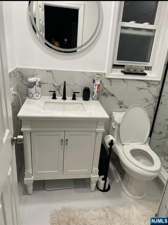62 Frederick Street, Unit 1 Hackensack, NJ 07601 - Photo 16 of 18 a bathroom with a toilet a flat screen tv and a toilet
