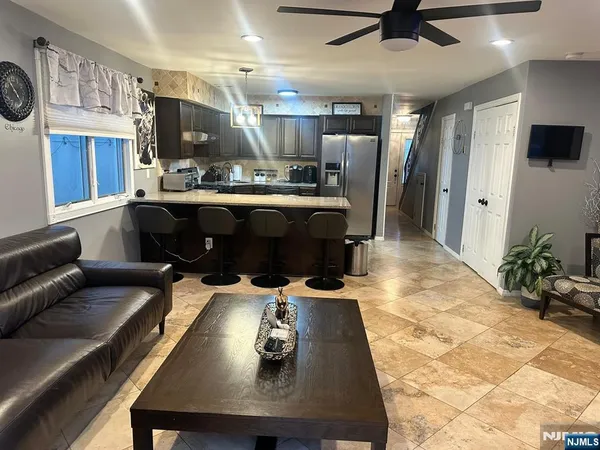 a living room with stainless steel appliances kitchen island granite countertop furniture and a view of kitchen