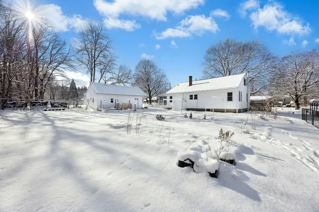 a view of white house with a yard covered in snow
