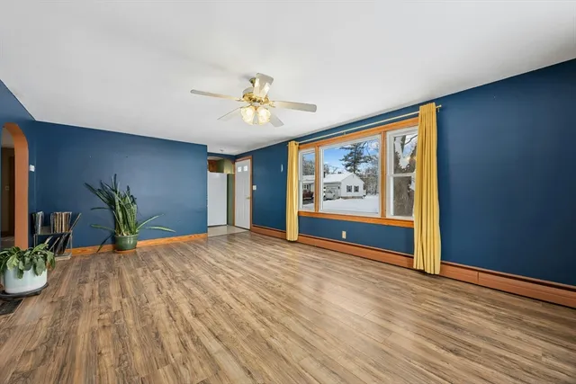 a view of an empty room with painting on the wall and a potted plant