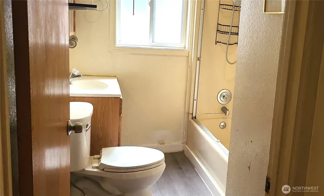 a bathroom with a granite countertop toilet and a sink